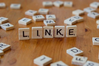 A wooden table topped with scrabble tiles spelling the word link
